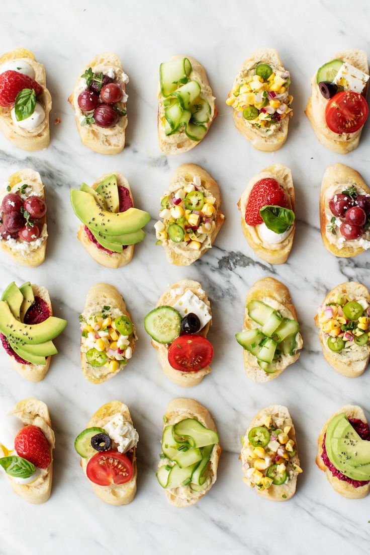 an assortment of finger foods arranged on a marble surface