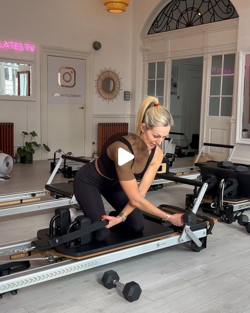 a woman is working out on an exercise bike in a gym with other machines and equipment