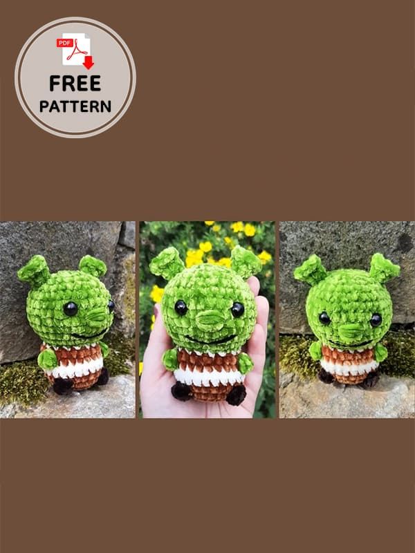 there is a small crocheted green creature with teeth on it's head