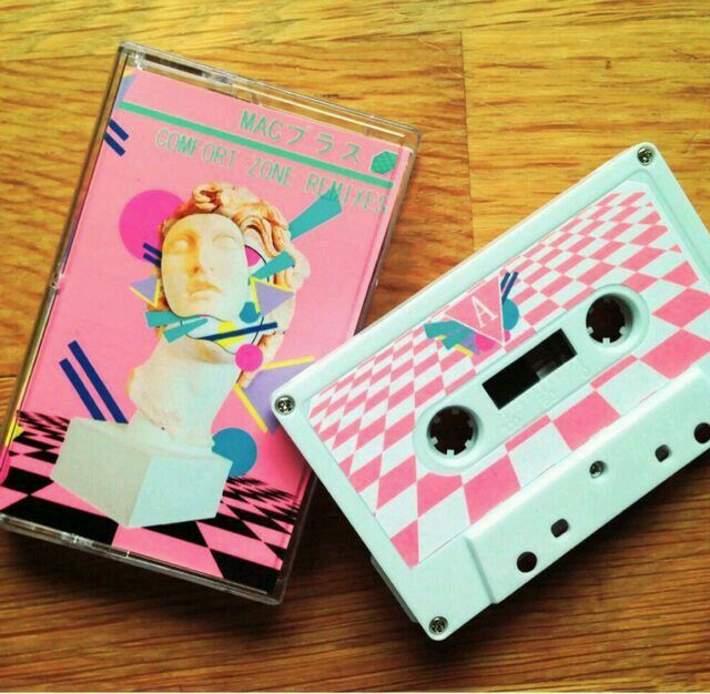 two cassettes sitting next to each other on top of a wooden table with pink and white designs