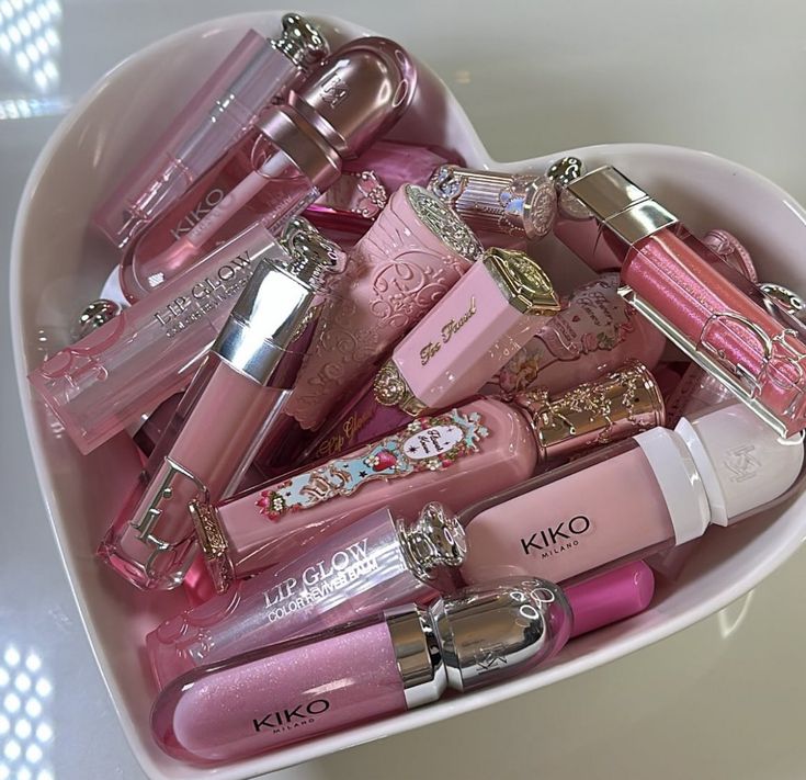 a heart shaped container filled with lots of pink lipstick