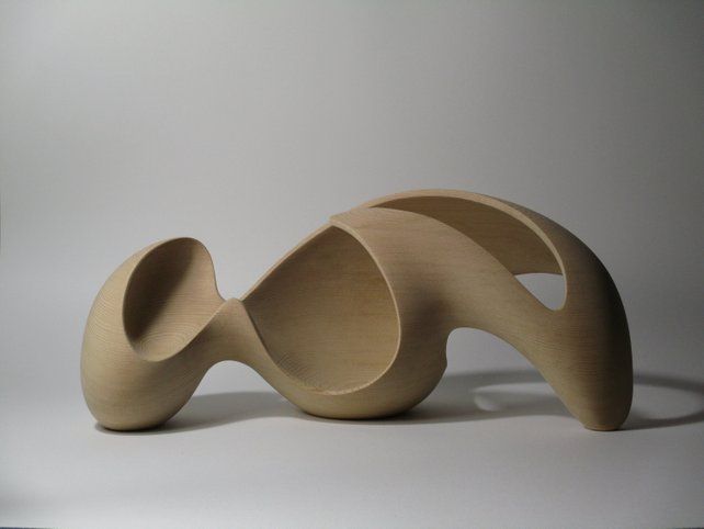 a wooden sculpture sitting on top of a white table