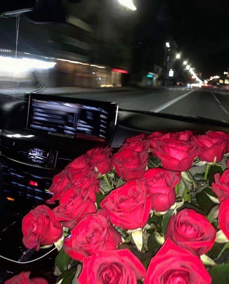 a bunch of red roses sitting in the front seat of a car