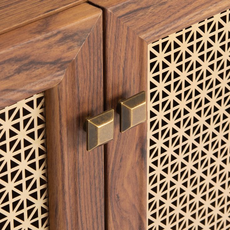 a wooden cabinet with two brass handles on it's sides and an intricate lattice design