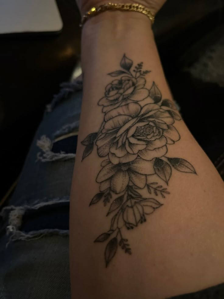 a woman's arm with a flower tattoo on it