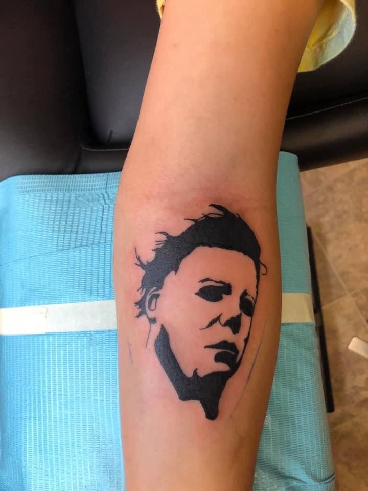 a person with a tattoo on their arm that has a drawing of a man's face