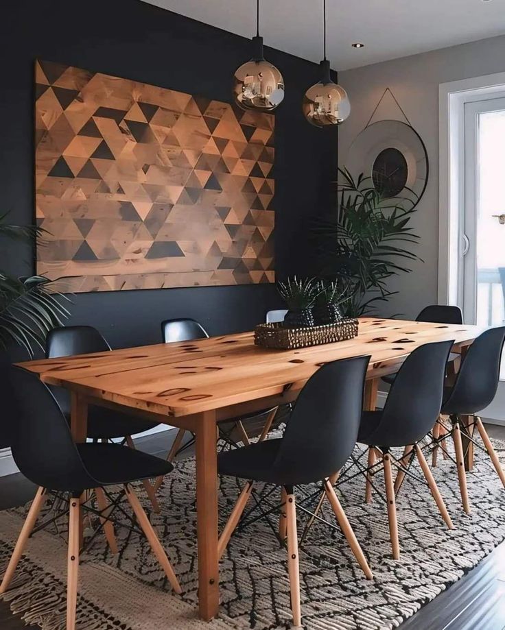 a dining room table with black chairs and a large wooden art piece on the wall