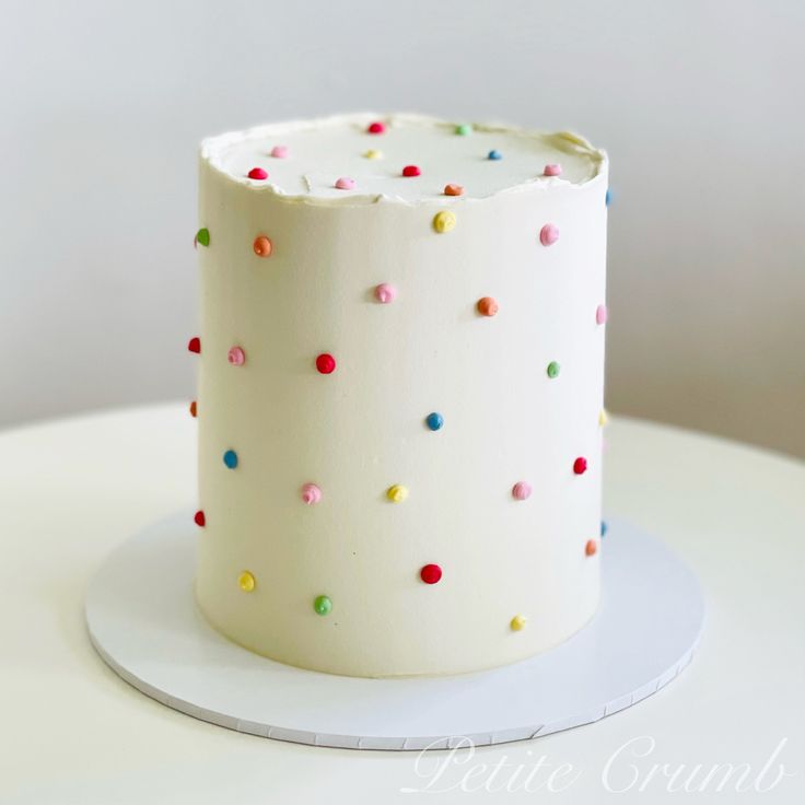 a white cake with multicolored sprinkles on it