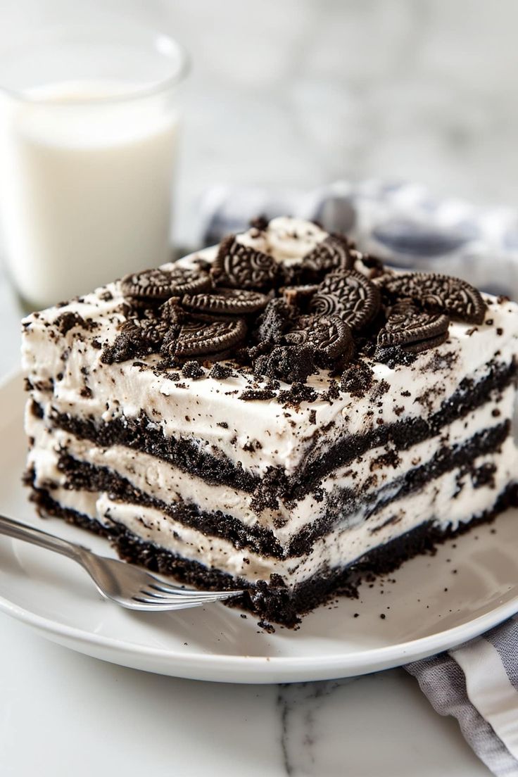 a piece of oreo cake on a plate with a glass of milk