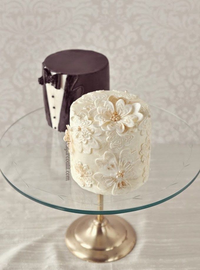 two cakes sitting on top of a glass cake plate with the words mini cakes above them