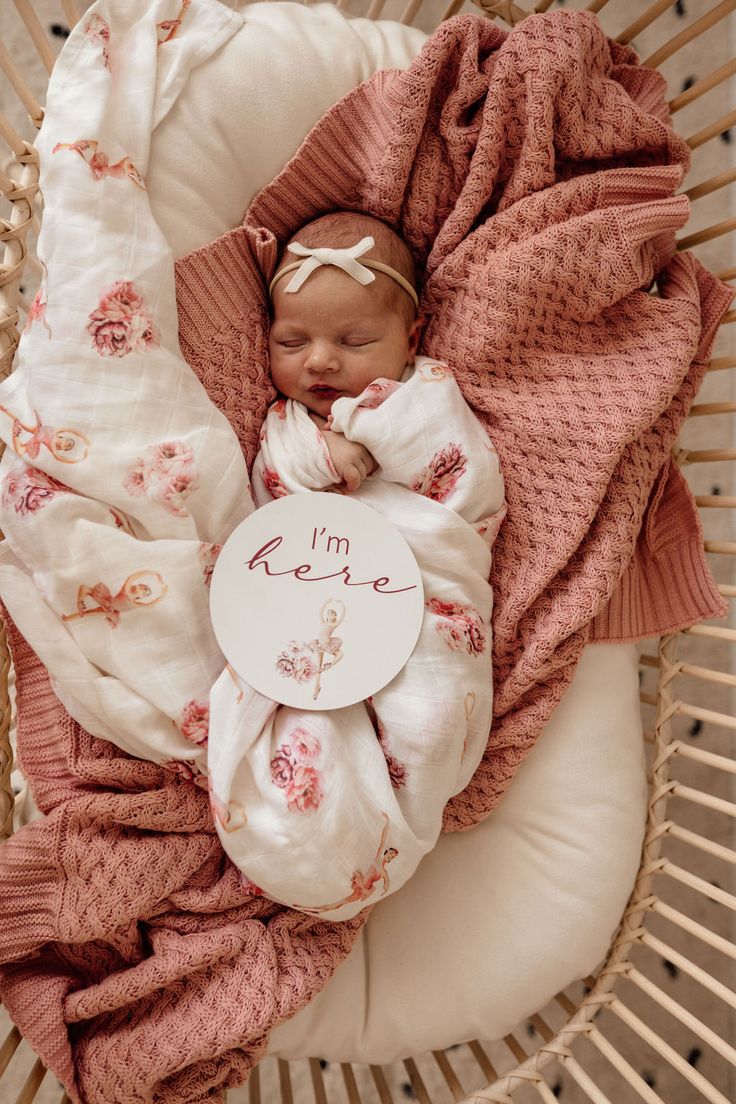 a newborn baby wrapped in pink and white blankets