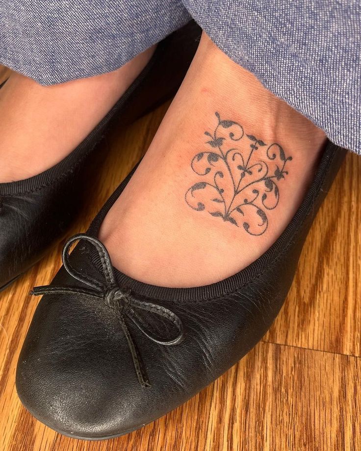 a woman's foot with a tattoo on it