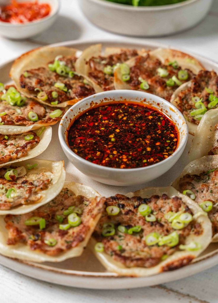 an appetizer platter with small tortillas and sauce on the side