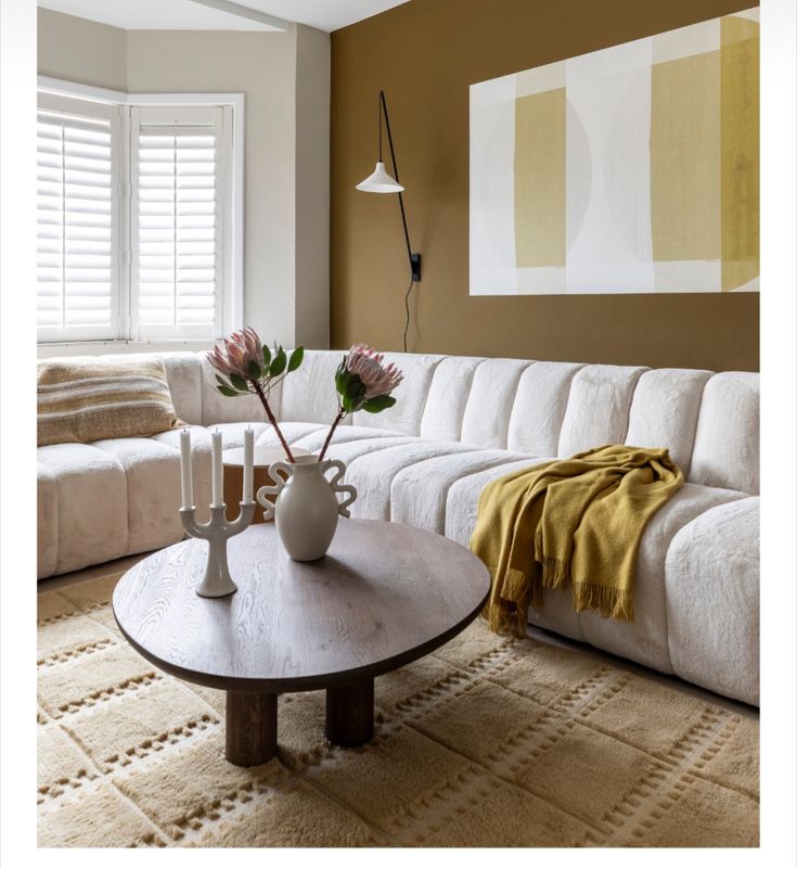 a living room filled with furniture and a large white couch next to a coffee table