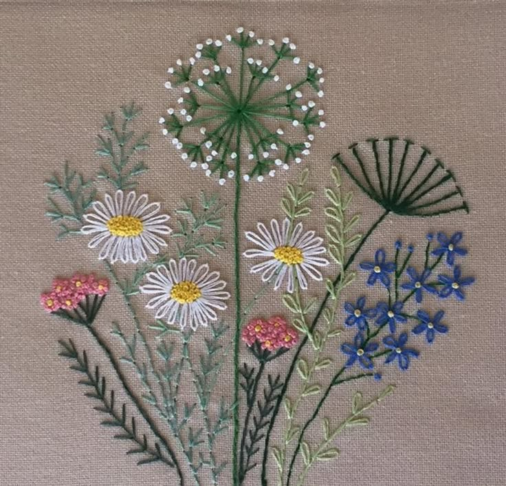 the embroidery is done with different colors and designs on it, including daisies and other flowers