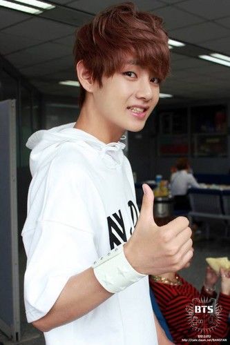 a young man giving the thumbs up sign