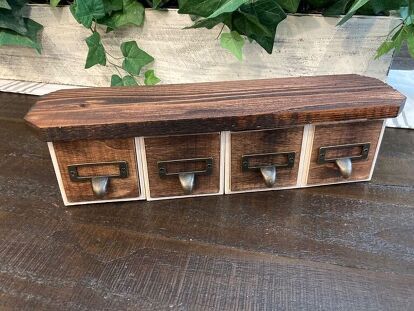 a wooden box sitting on top of a hard wood floor next to green planters