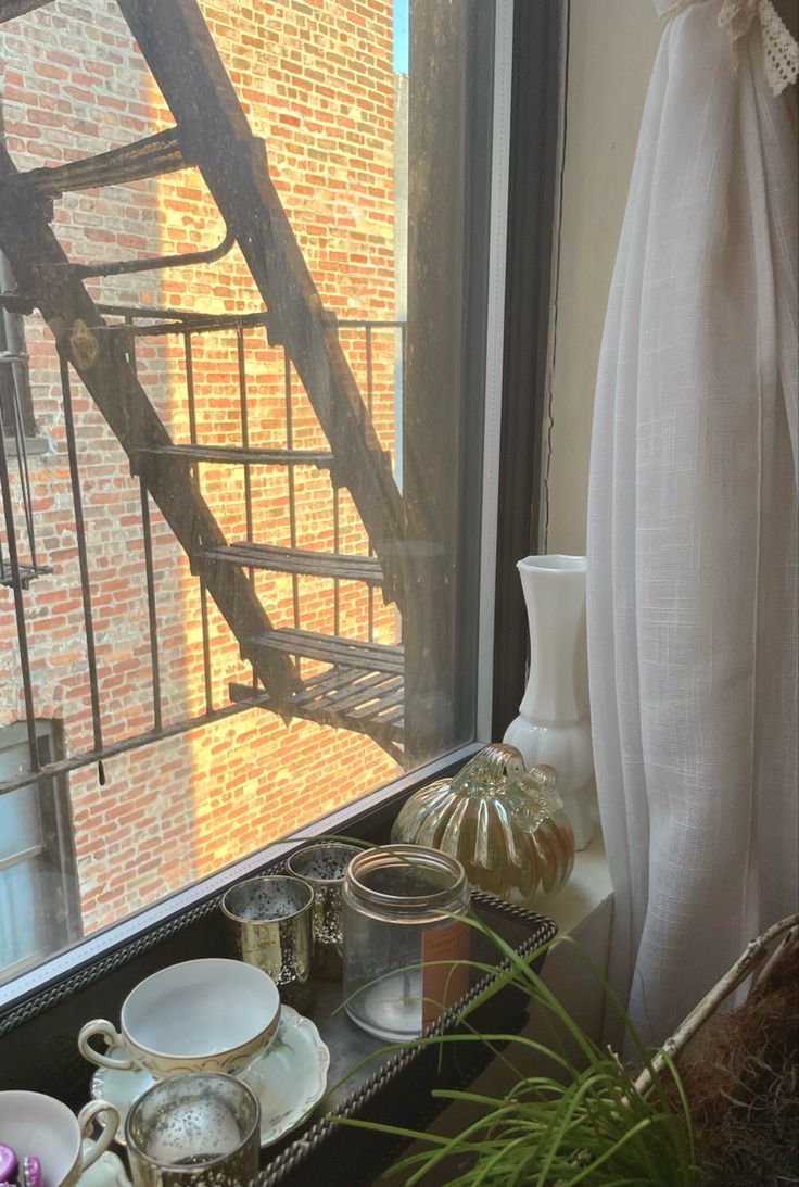 a window sill filled with dishes and cups