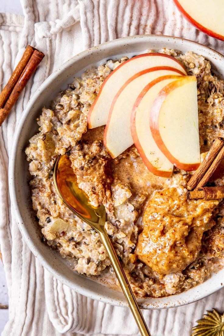 an oatmeal bowl with apples and cinnamon sticks