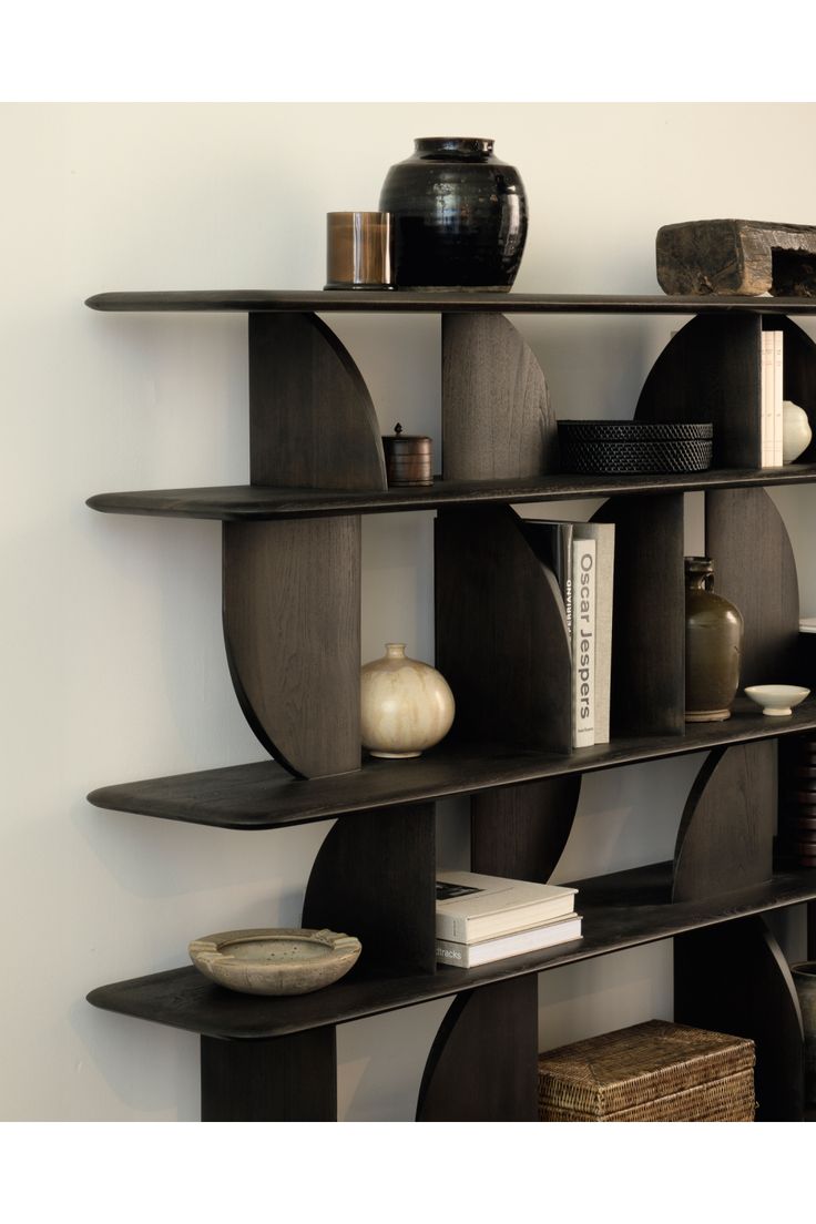 a book shelf with books and vases on it