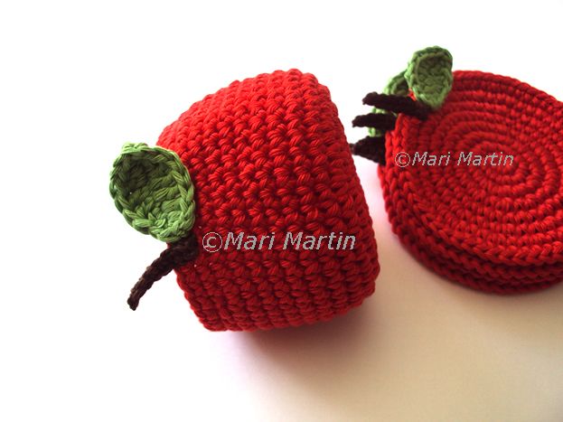 two crocheted strawberries sitting on top of each other