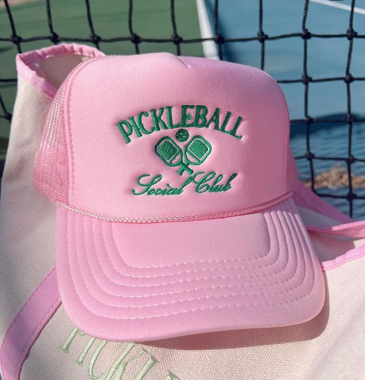 a pink pickleball hat sitting on top of a tennis court