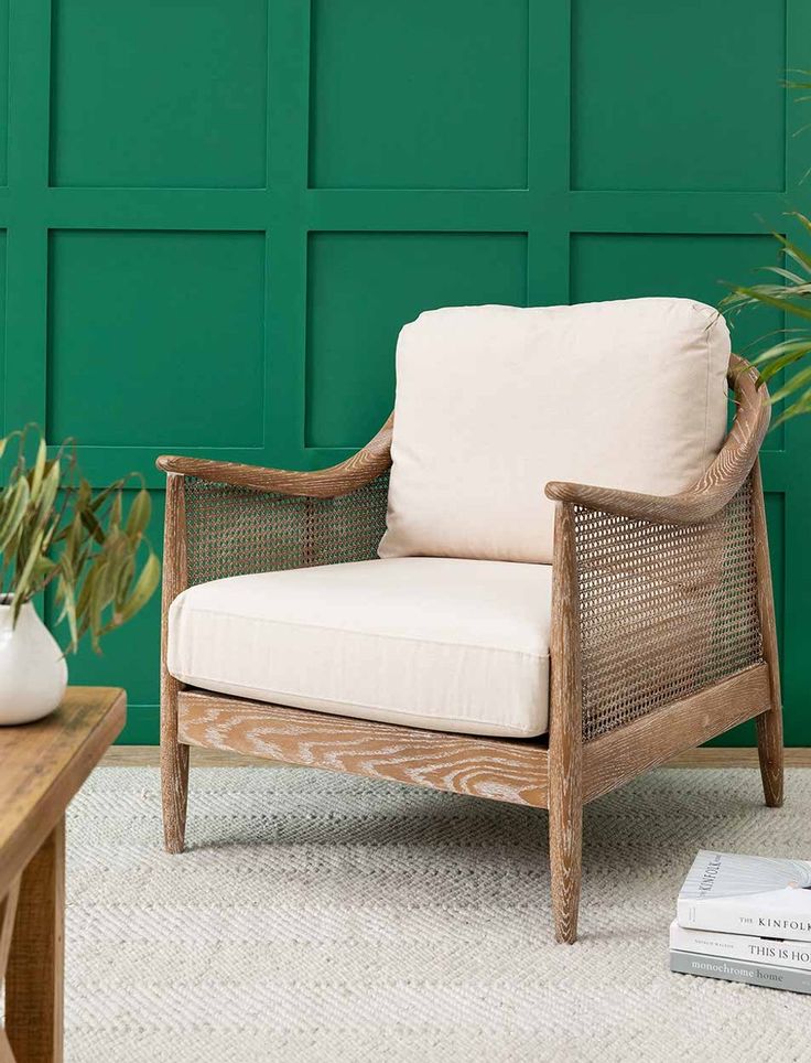 a living room with green walls and a white rug on the floor next to a chair