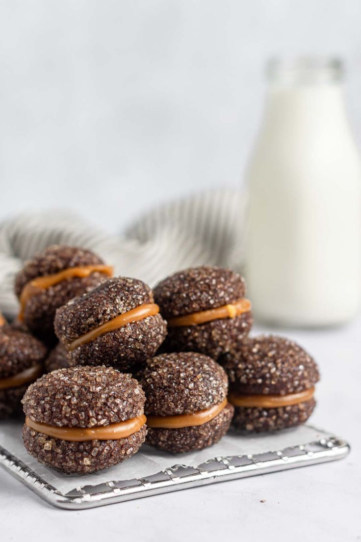 chocolate covered donuts with peanut butter on them and a glass of milk in the background