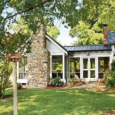 a brick house with white windows and a black roof is surrounded by green grass in the front yard