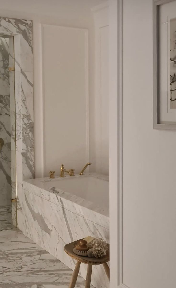 a bathroom with marble walls and flooring next to a bathtub in the corner