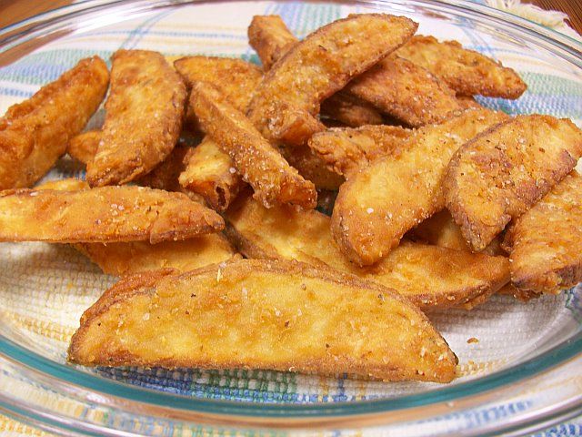 some fried food on a glass plate with a blue and white checkered table cloth