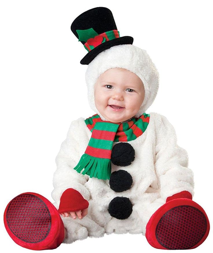 a baby dressed in a snowman costume sitting on the ground with his legs crossed