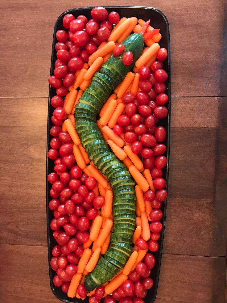 a tray filled with fruits and vegetables on top of a wooden table