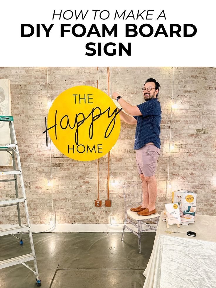 a man standing on a step ladder holding a sign that says how to make a diy foam board sign