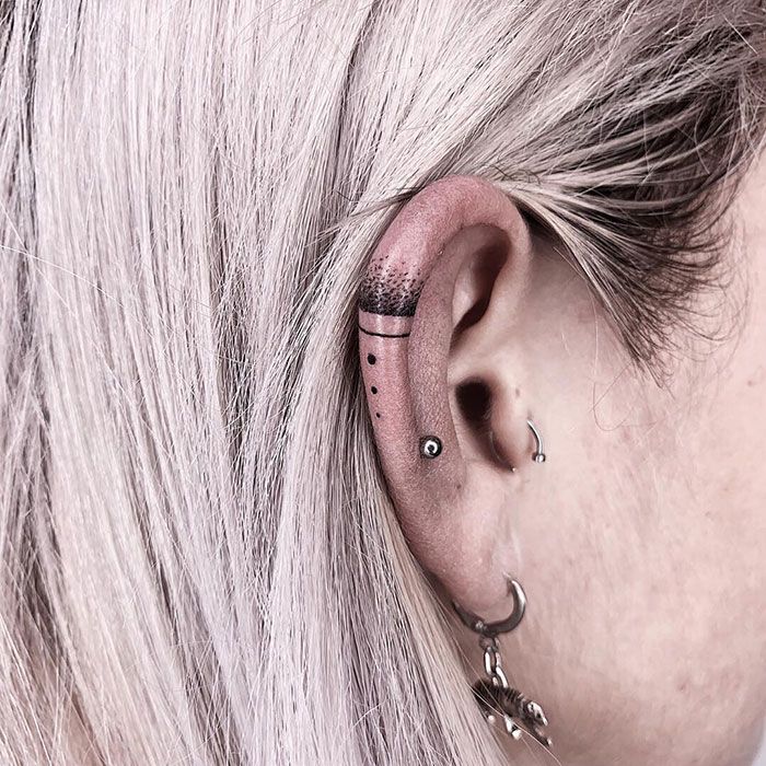 a woman with grey hair and piercings on her ear