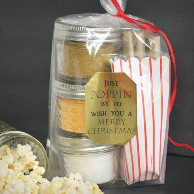 a bag with some popcorn in it sitting next to a glass jar filled with candy