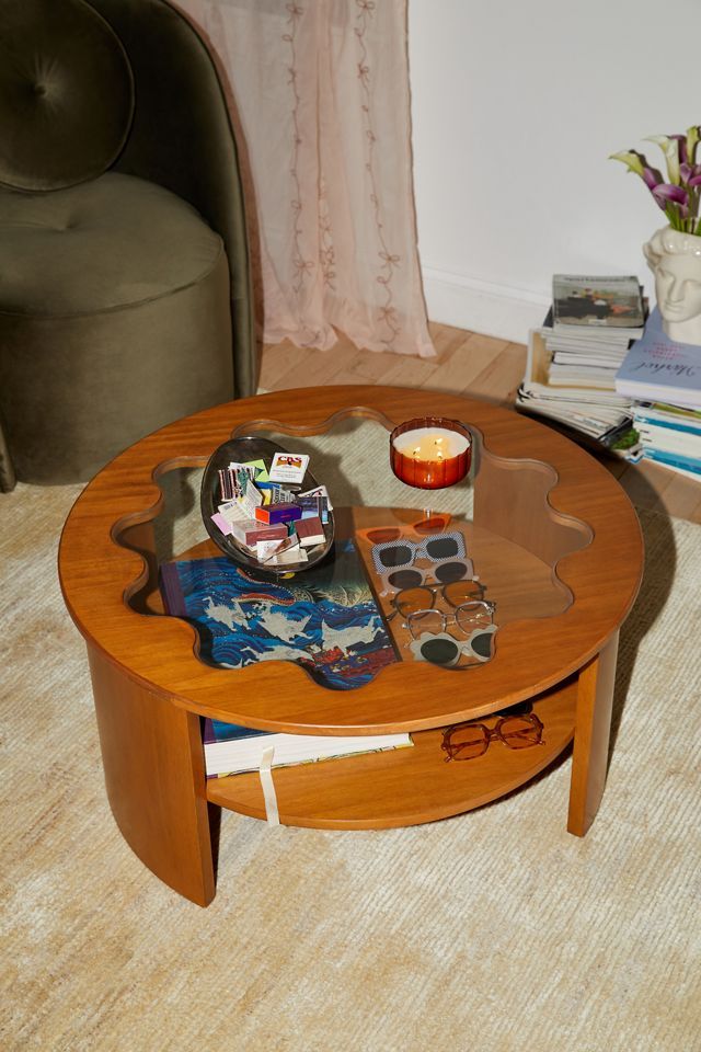 a coffee table with a candle and other items on it in a living room area