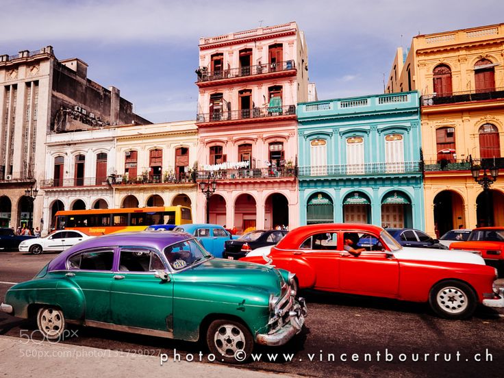 old cars parked in front of colorful buildings