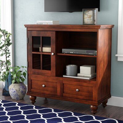 an entertainment center with a flat screen tv mounted on it's side, in a living room