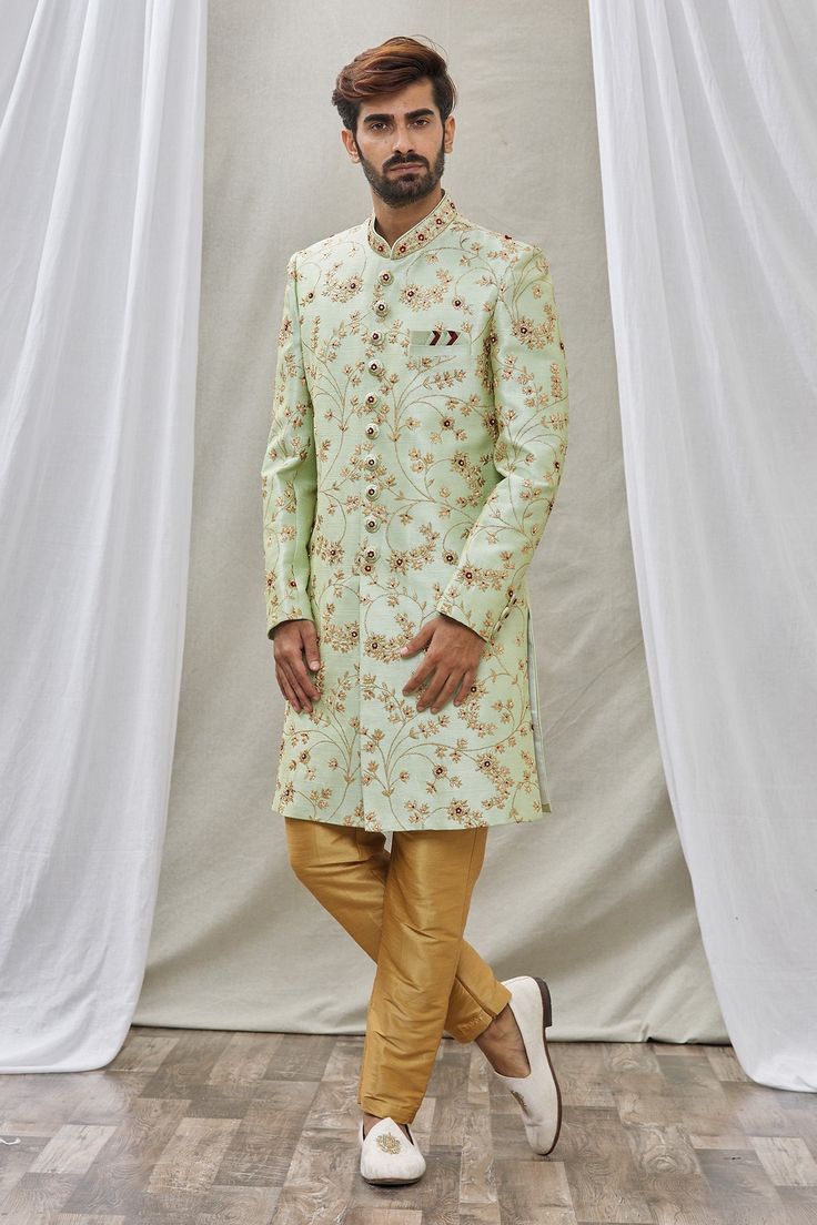 Pista green sherwani with floral embroidery and mandarin collar. Paired with pant.
Component: 2
Pattern: Embroidered
Type Of Work: Floral
Neckline: Mandarin
Sleeve Type: Full Sleeves
Fabric: Art Banarasi Silk, Dupion Art Silk
Color: Green
Other Details: 
Floral embroidery
Front buttons
Note: Pocket square worn by the model is not for sale
Occasion: Wedding - Aza Fashions Green Traditional Wear With Naqshi For Eid, Green Naqshi Traditional Wear For Eid, Festive Green Churidar With Naqshi Details, Festive Green Churidar With Naqshi, Semi-stitched Green Bollywood Sherwani, Green Naqshi Kurta For Wedding, Green Kurta With Naqshi In Traditional Drape, Green Kurta With Naqshi And Traditional Drape, Green Naqshi Traditional Wear For Festivals