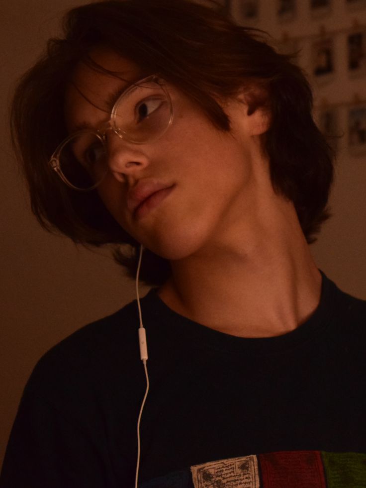 a young man wearing glasses and headphones is looking at something in front of him