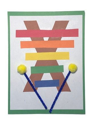 an art project made out of construction paper and colored yarn with two yellow balls on top