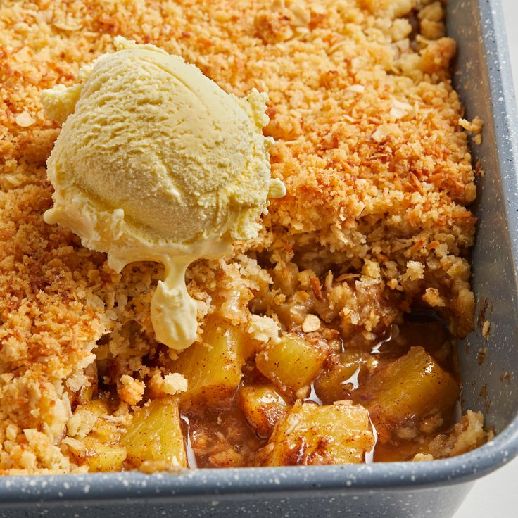 a scoop of ice cream on top of some food in a blue dish with crumbs