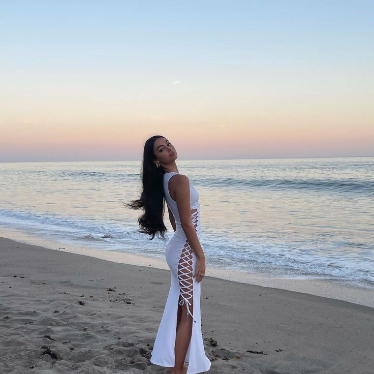 a woman standing on top of a sandy beach