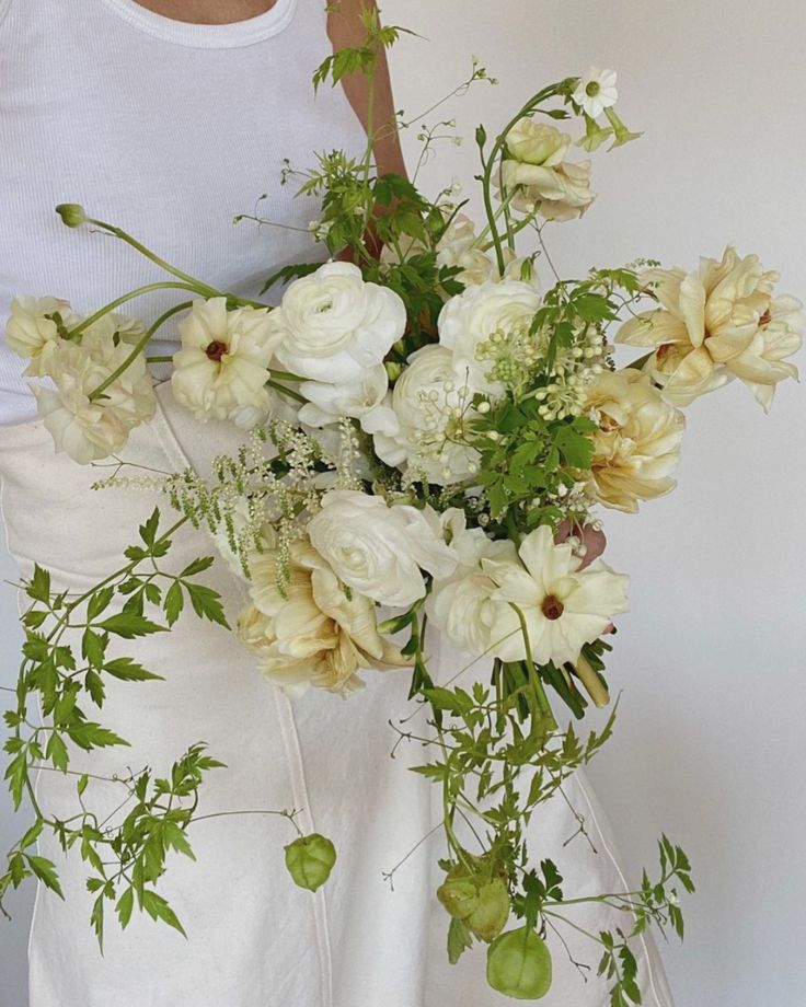 a woman holding a bouquet of flowers in her hands