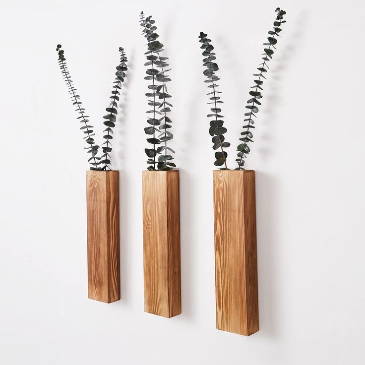 three wooden vases with plants in them