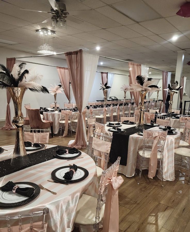 tables and chairs are set up for a formal function in a banquet hall with black and white decor