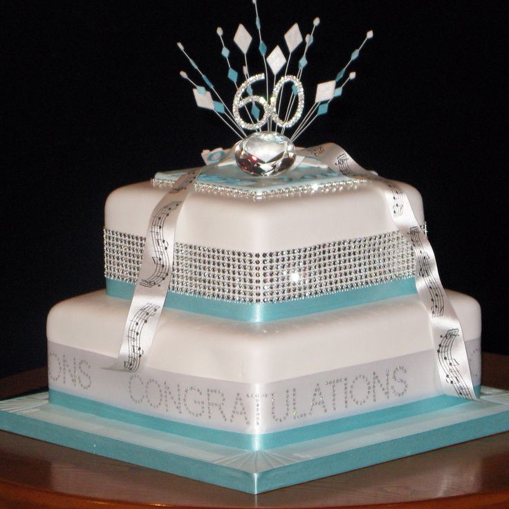 a three tiered cake decorated with ribbons and jewels