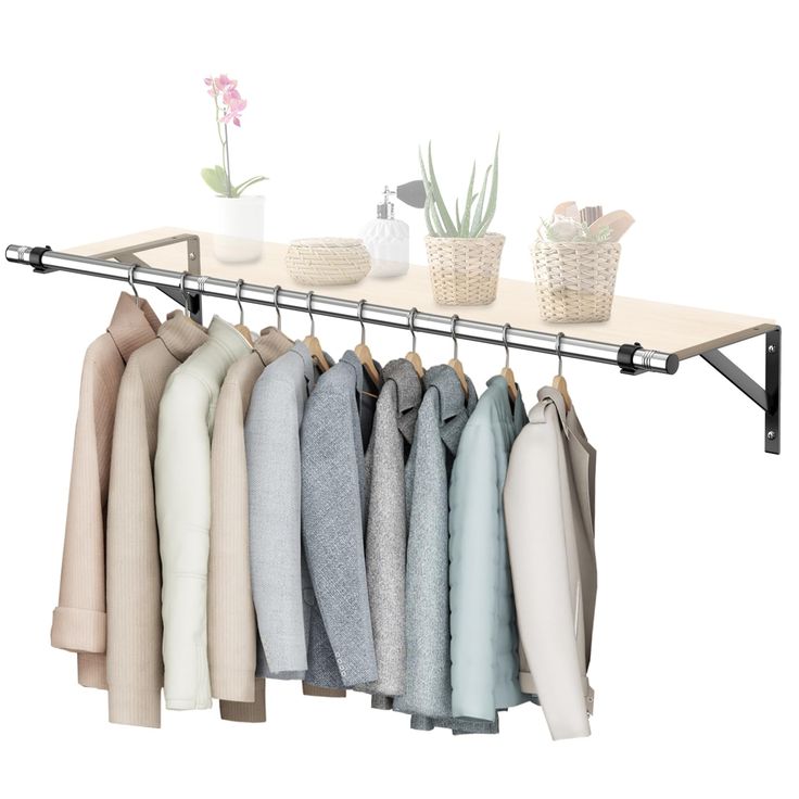 an ironing rack with clothes hanging on it and a potted plant next to it