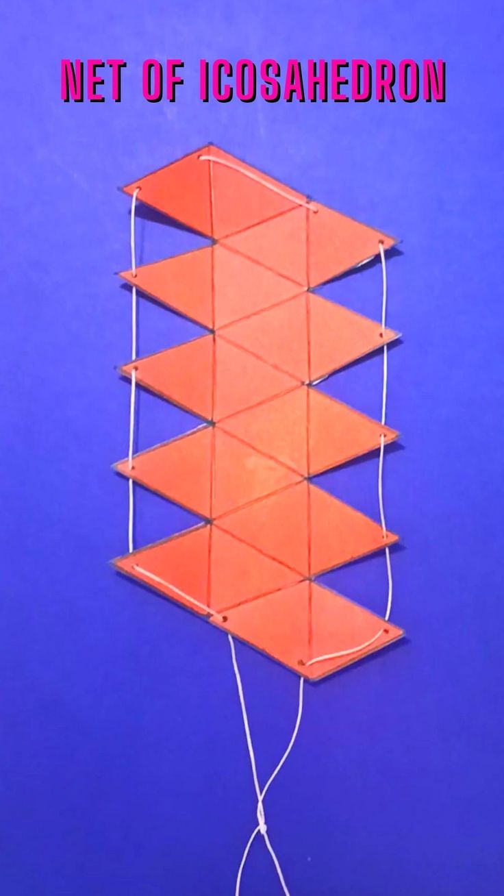 an orange piece of paper hanging from a string on a blue background with the words net of icosahedron above it